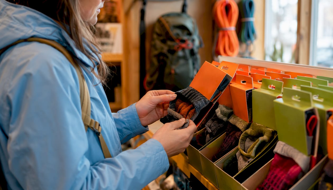 Hand selecting anti-blister sock in hiking shop