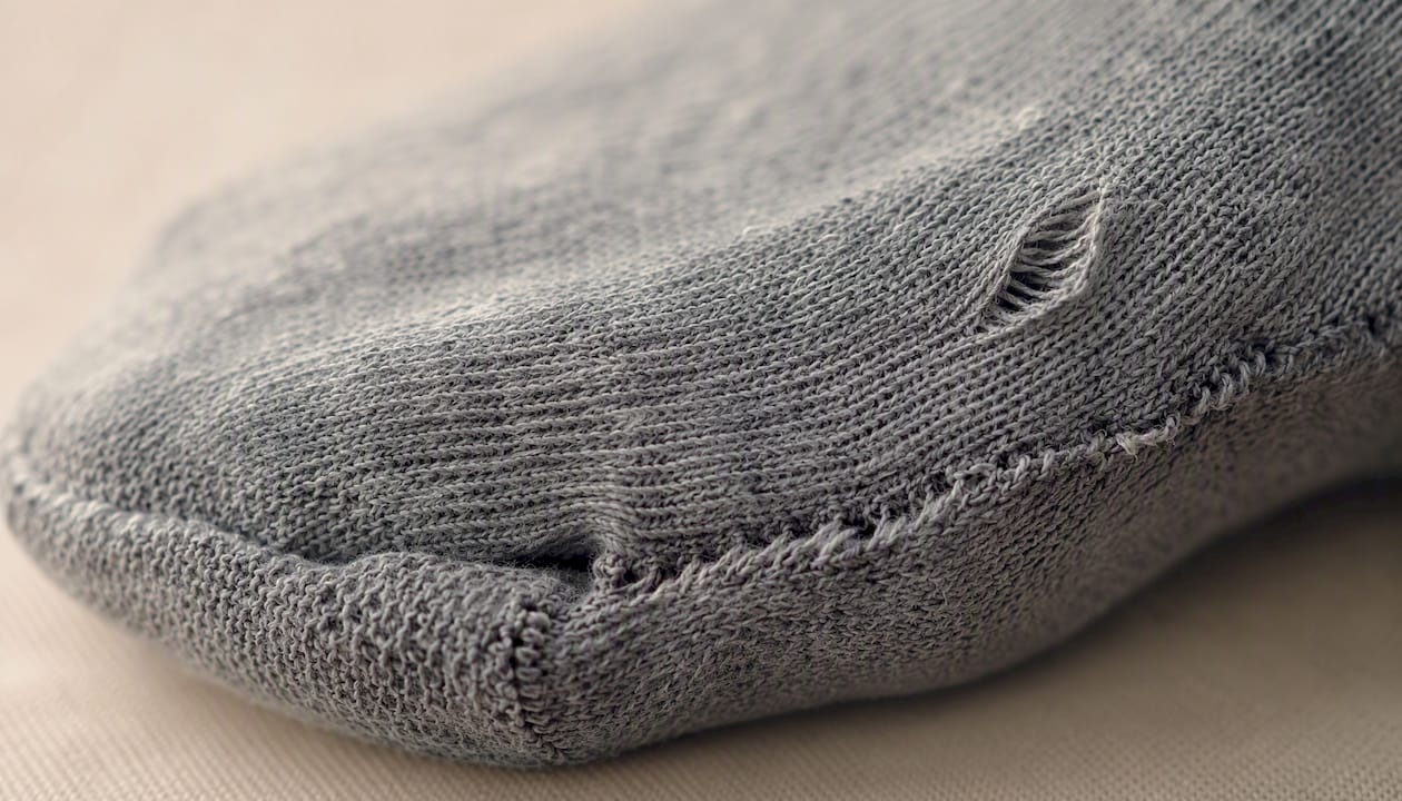 Close-up of sock fabric defects and seam irregularities