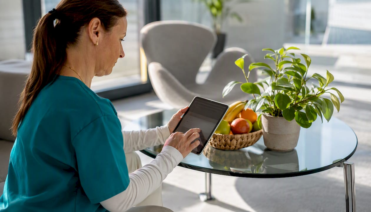 Kézben tartott tablet kijelzőjén tölt ki valaki egy online űrlapot