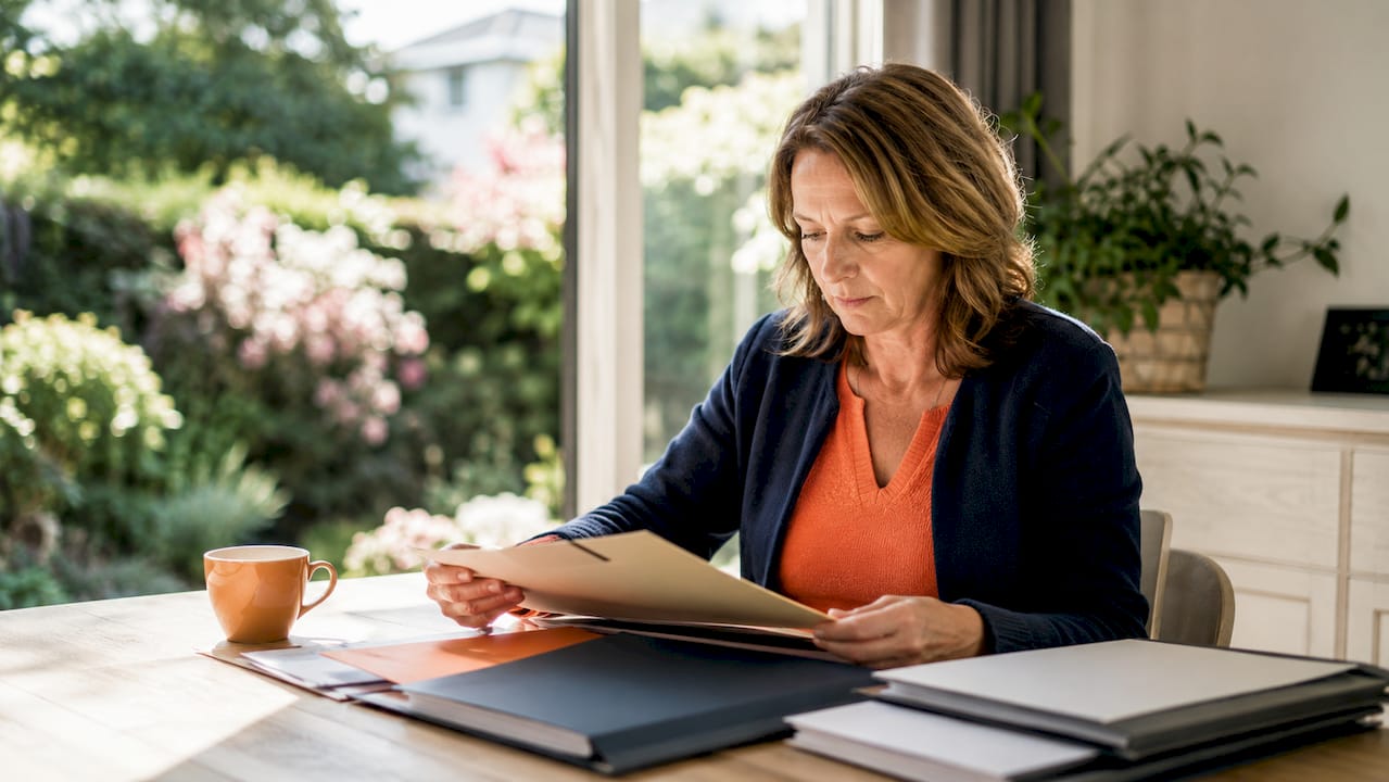 Vrouw maakt haar papieren in orde voor de verkoop van haar huis.