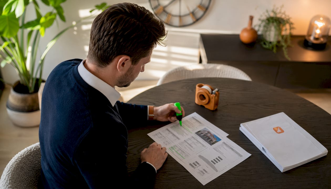 Handen wijzen belangrijke punten aan in een taxatierapport van een woning