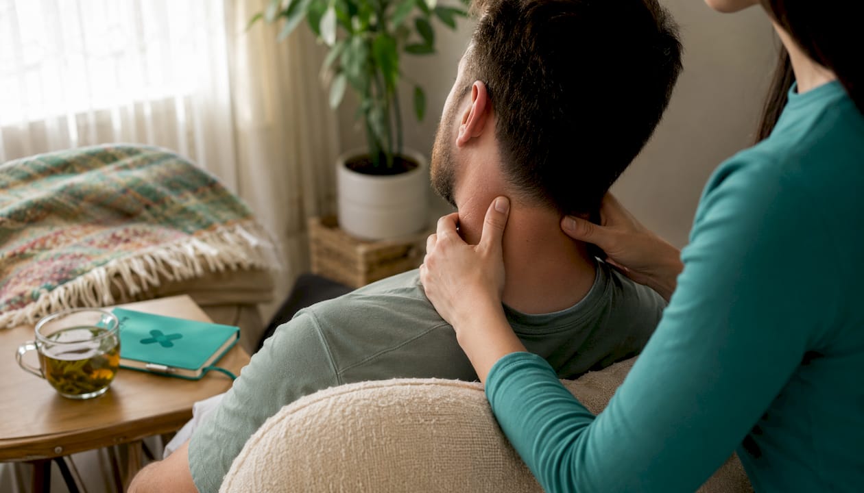 Hands massaging neck muscles in home office