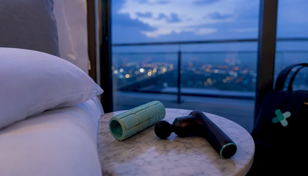 Compact foam roller and percussion device on hotel bedside table