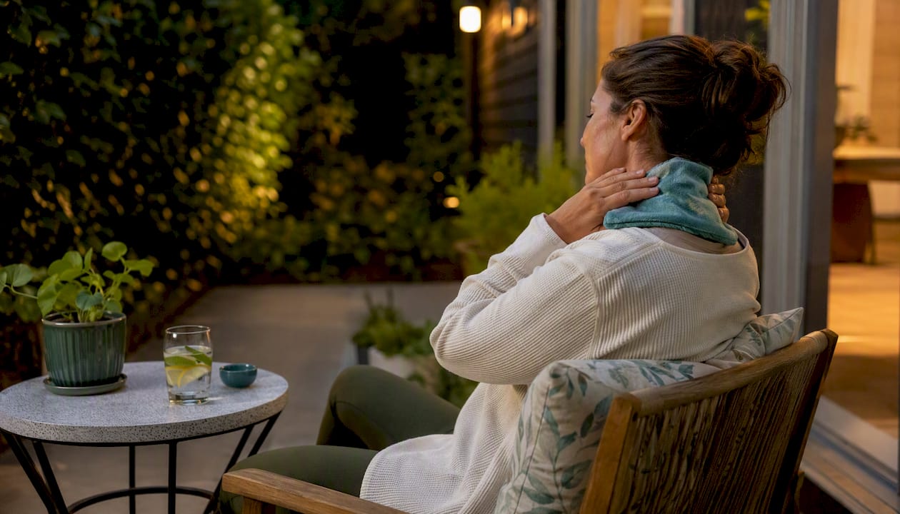 Applying warm compress to neck at home