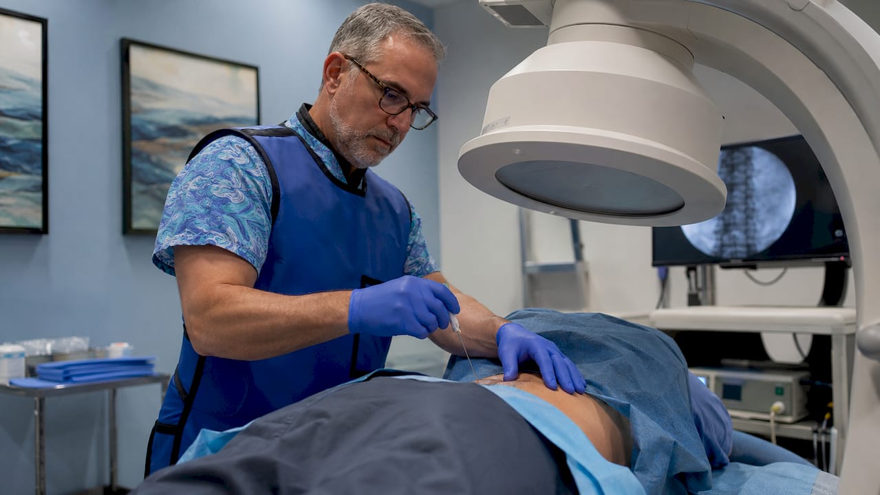 Radiologist conducting fluoroscopy-guided epidural injection