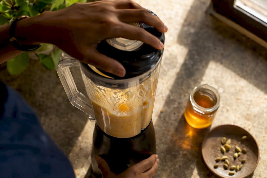 Blender blending mango lassi ingredients