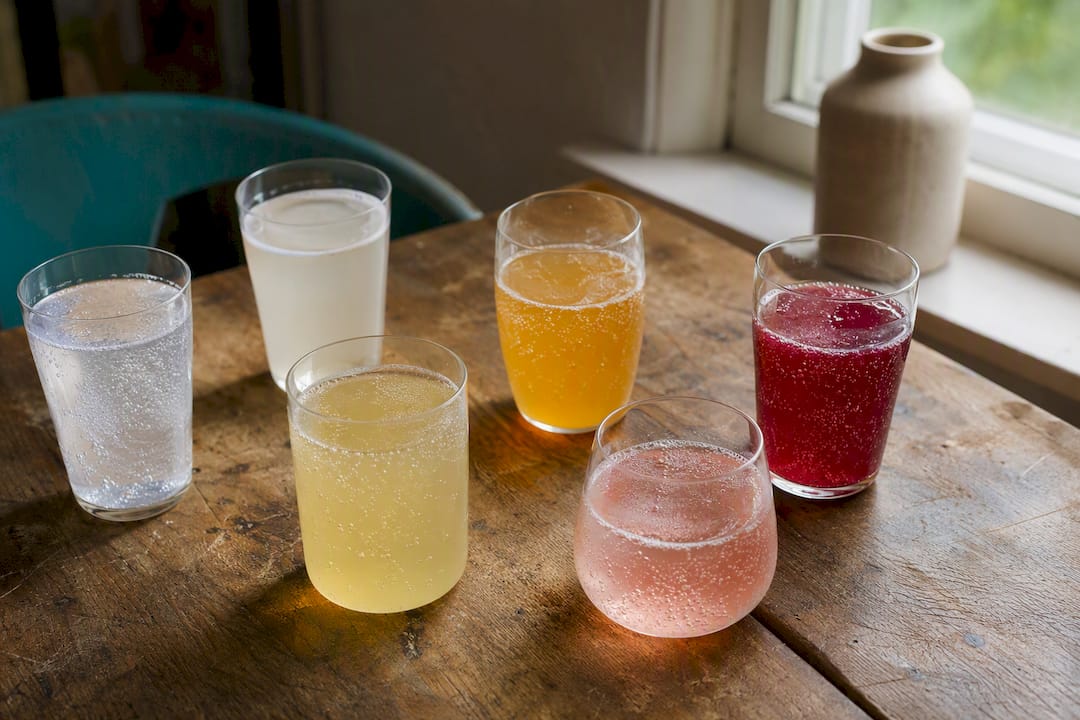 Glasses of kombucha, kefir, sparkling water, and prebiotic soda