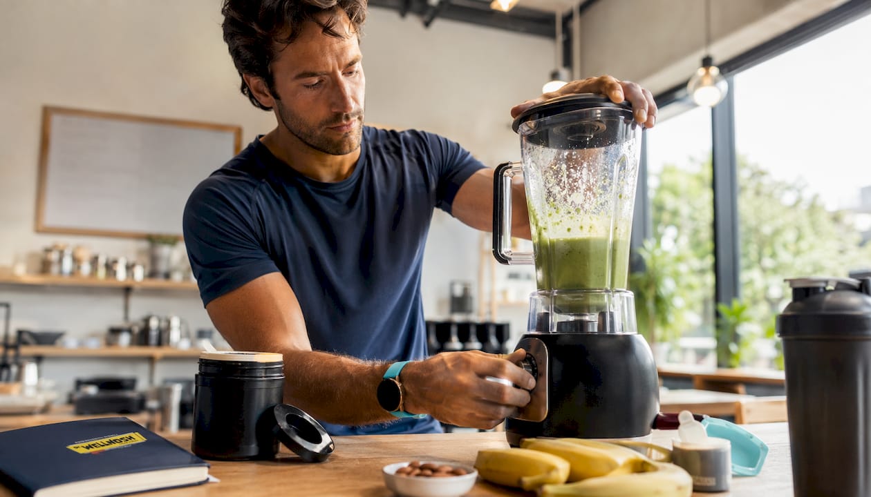 Athlete making plant protein smoothie in kitchen