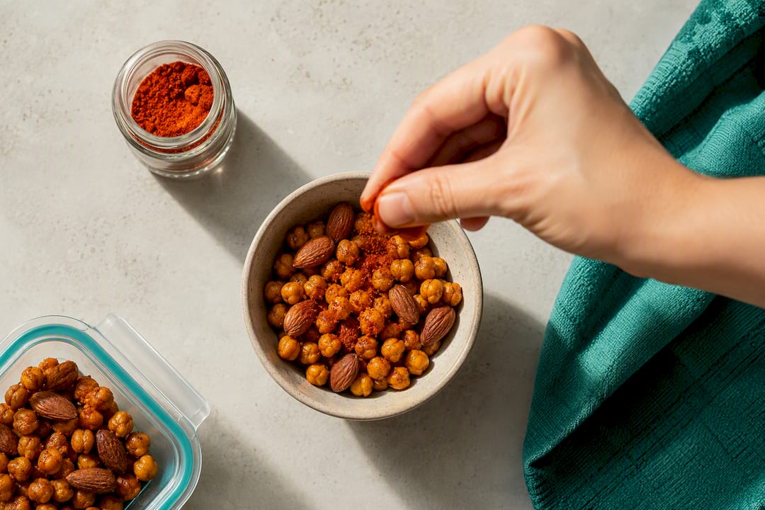 Hand seasoning roasted chickpeas and almonds