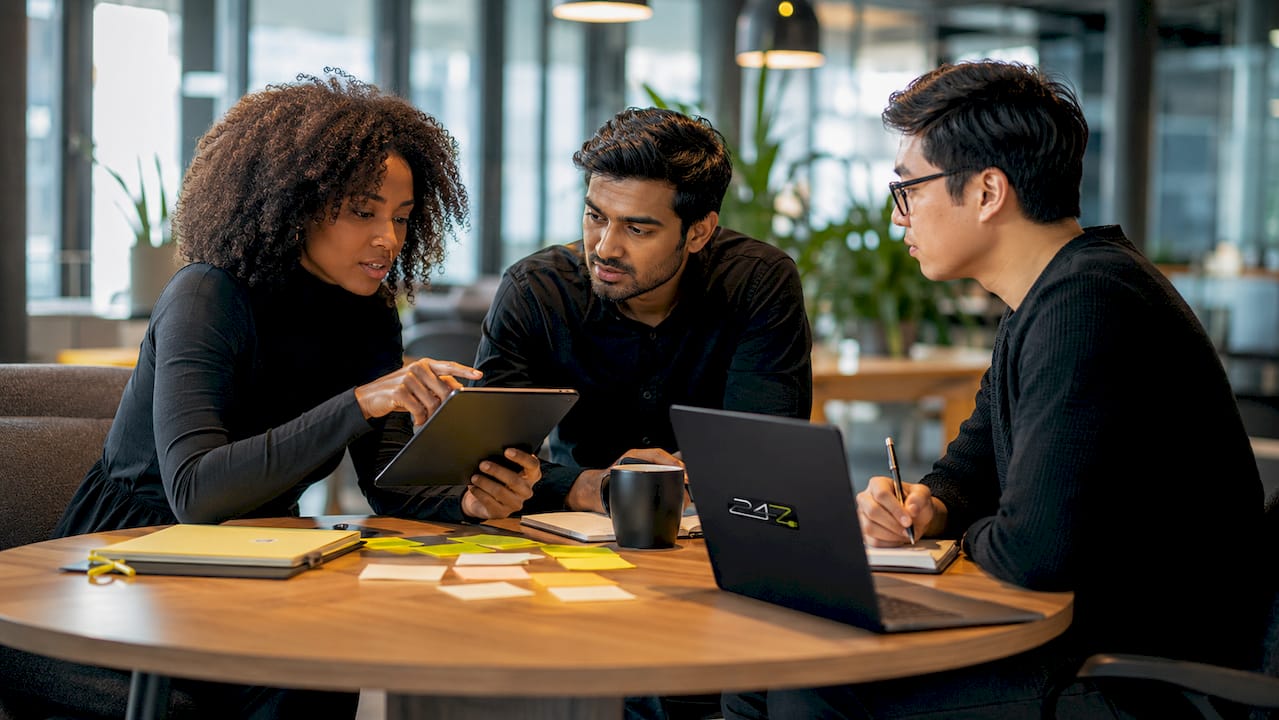 IT consultants collaborating around tech schematics