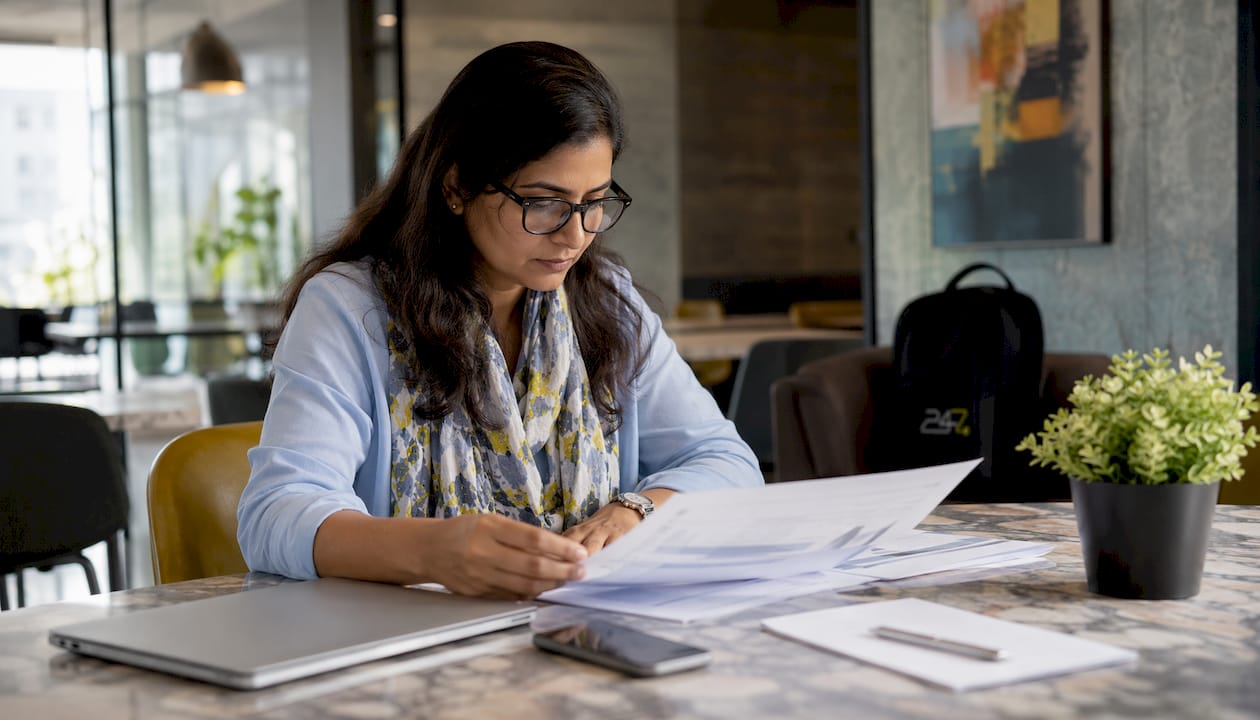 Woman reviewing IT regulatory compliance documents