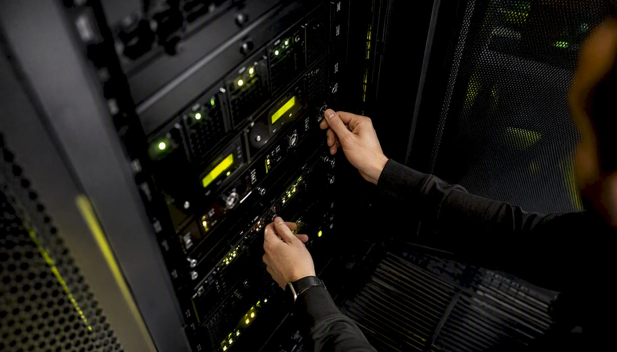 Technician adjusting controls on server rack