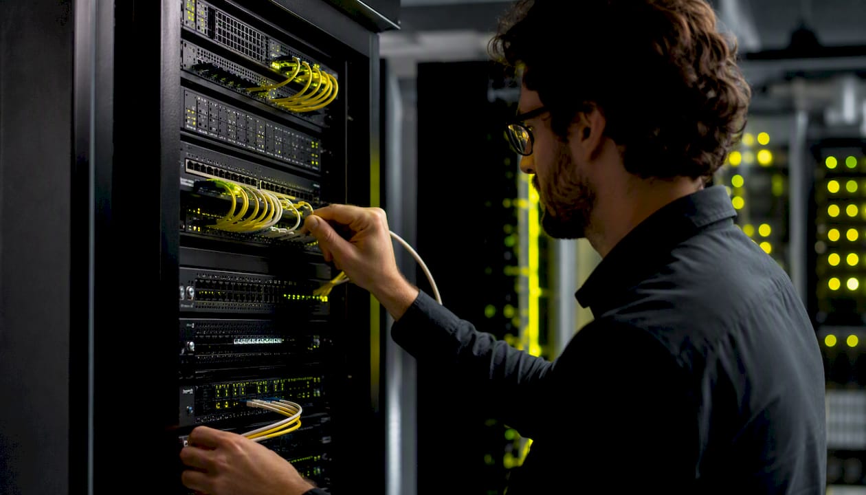 Hands connecting network cable in secure IT room