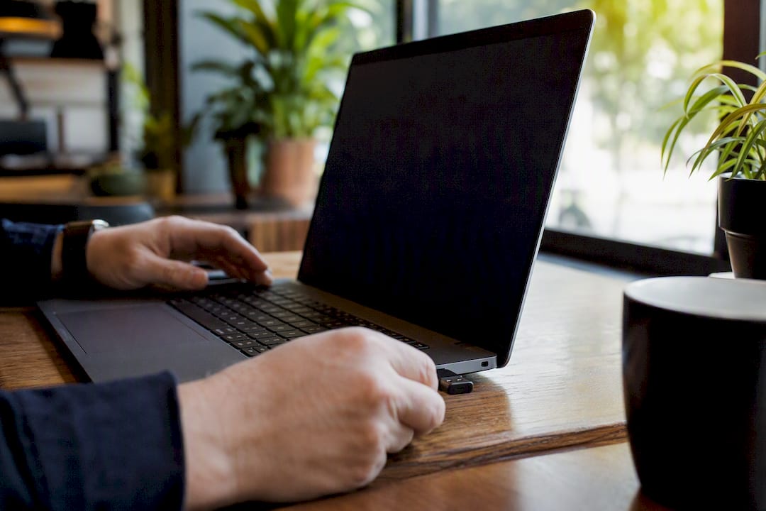 Hands inserting security key into laptop USB port