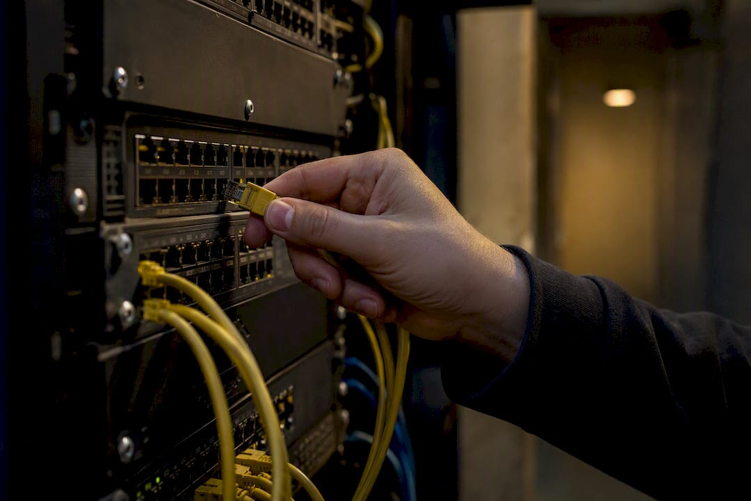 Hand unplugging cable on network switch