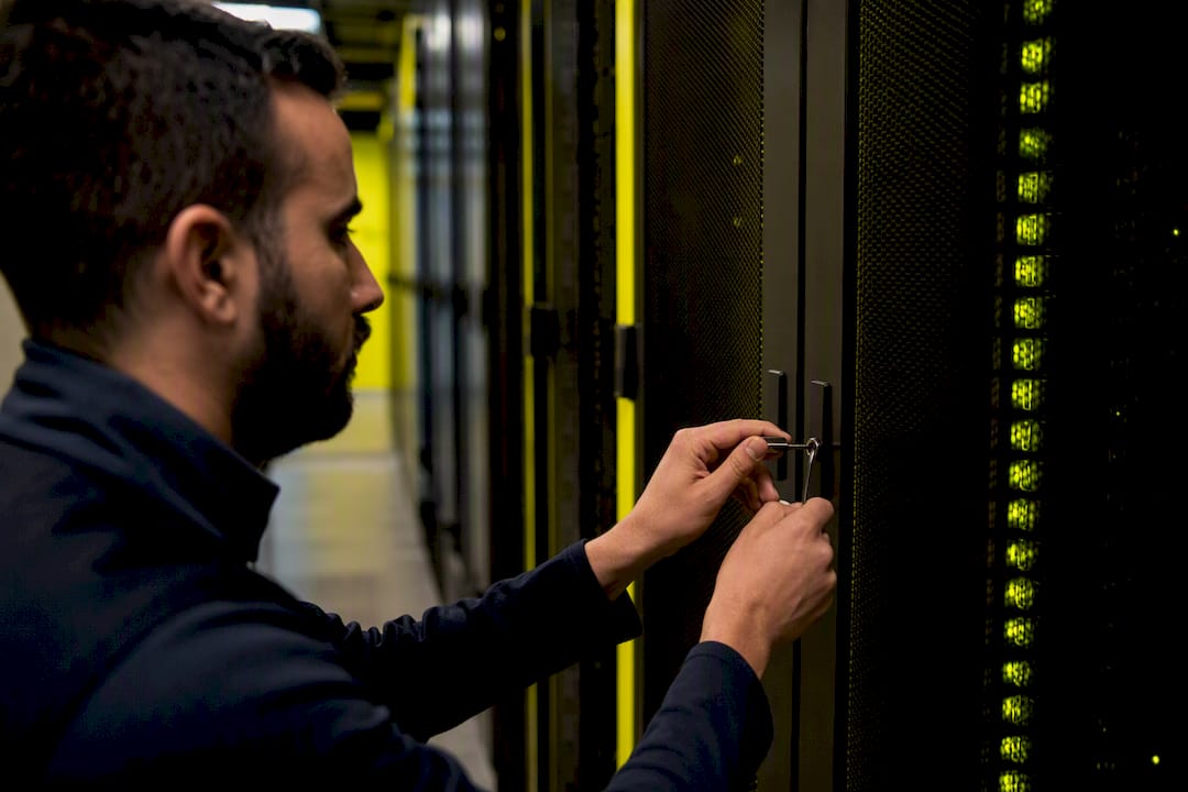 Hands locking server cabinet in data center aisle
