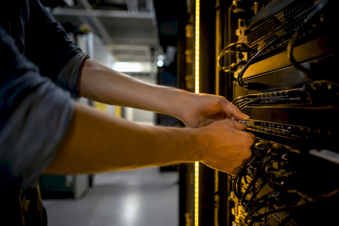 Hands connecting network disconnect tool in server room