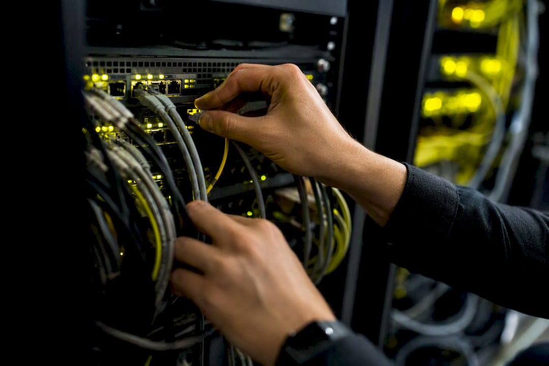 Hand connecting network cables to switch