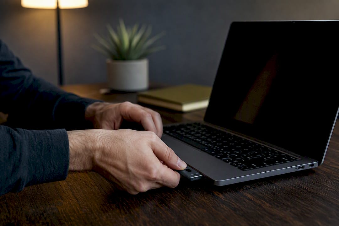 Hands inserting security token into laptop USB port