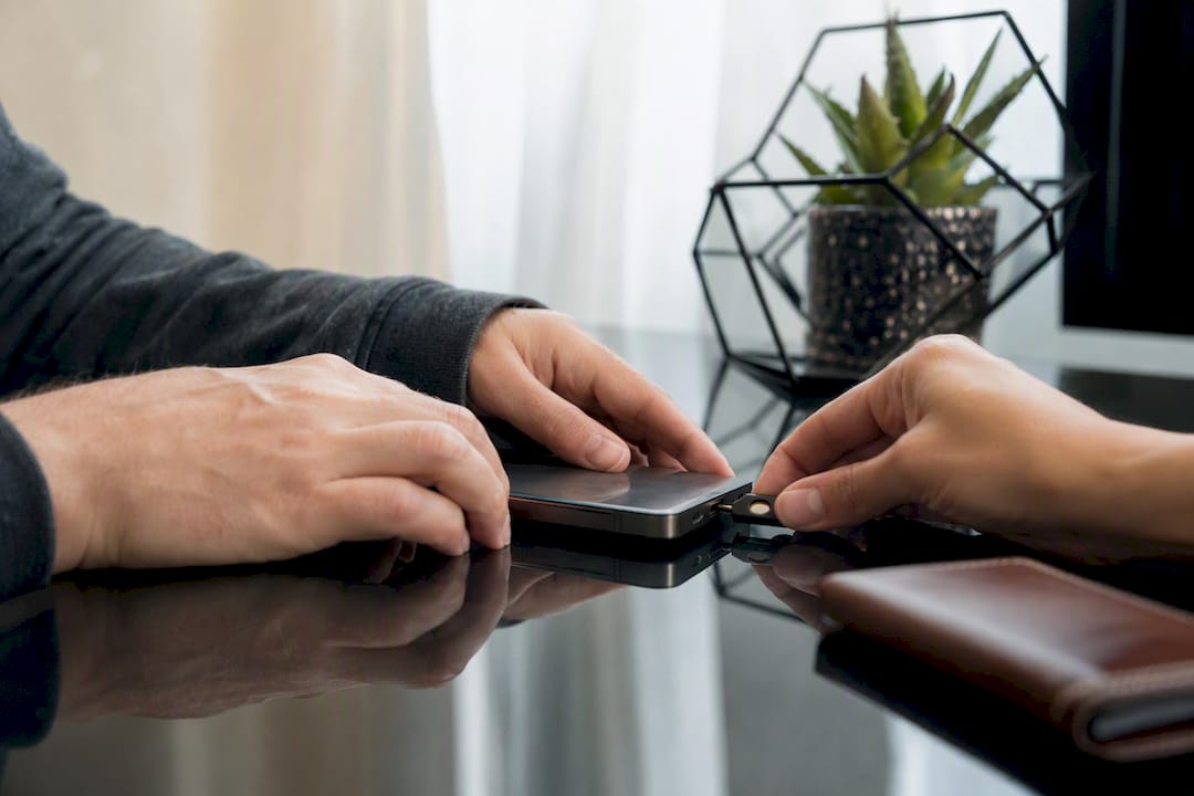 Hands attaching security key to smartphone