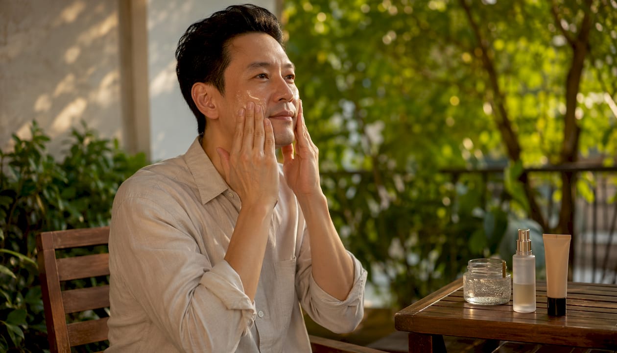 Hands applying gel moisturizer to man's face