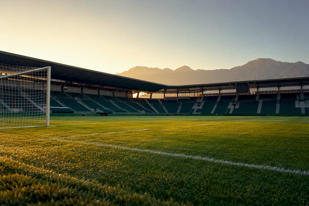 Empty Premier League stadium pitch at dawn