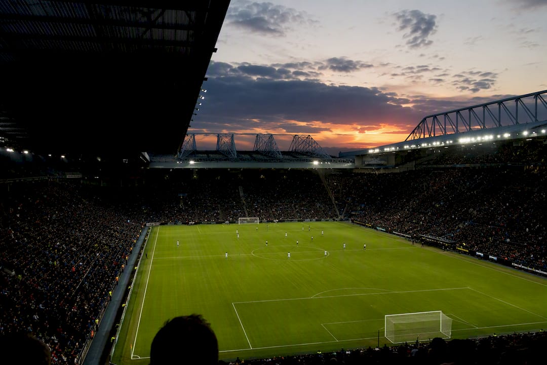 Historic football stadium pitch at sunset