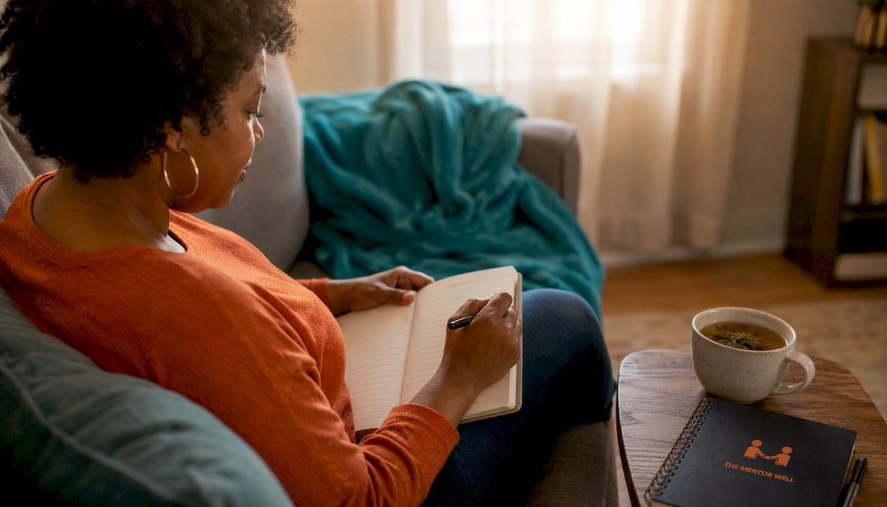 Parent writing mental health notes at desk