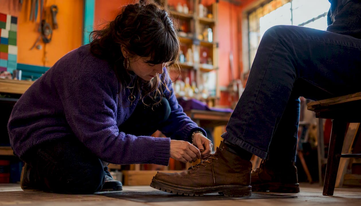 Peer supporter tying work boot shoelace