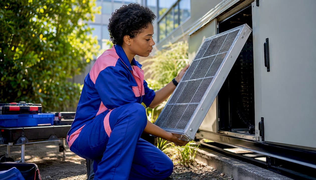 Technician removing and checking AHU air filter