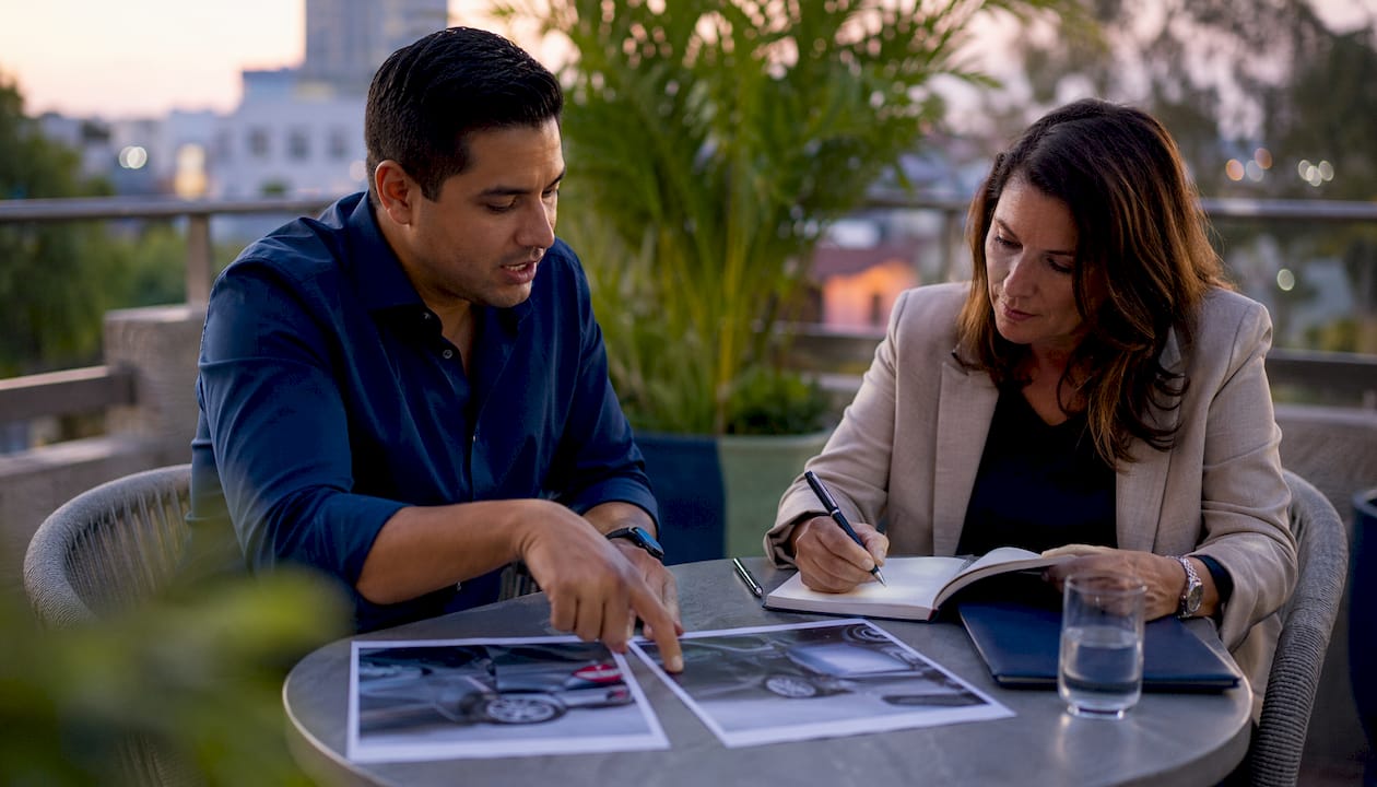 Two professionals discussing vehicle collision evidence