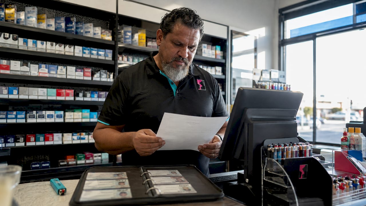 Shopkeeper reviewing tobacco sale compliance