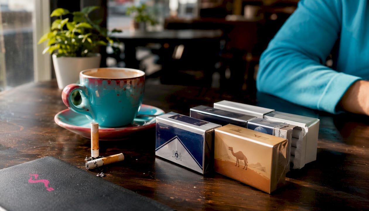 Overhead view of cigarette cartons and coffee cup on marble