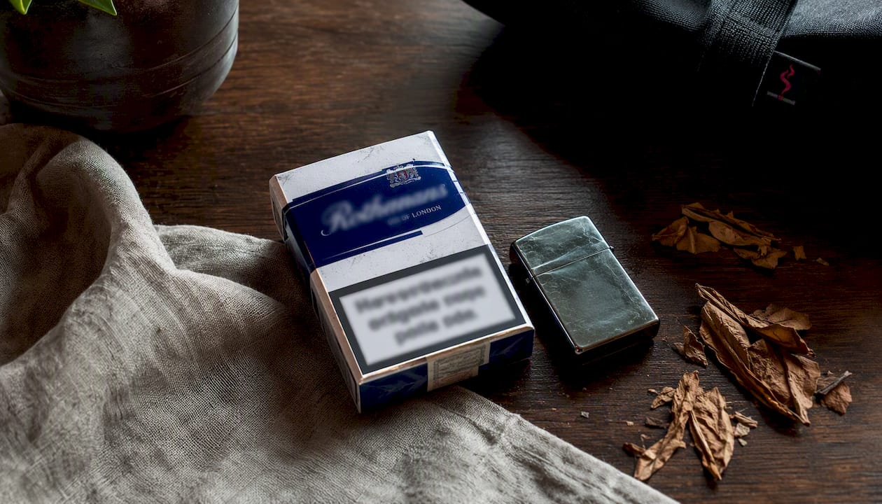 Cigarette pack with lighter and newspaper on marble table