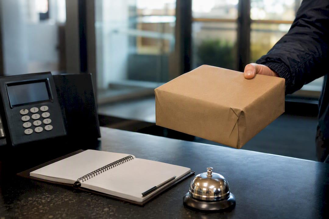 Courier delivering parcel at workplace security desk