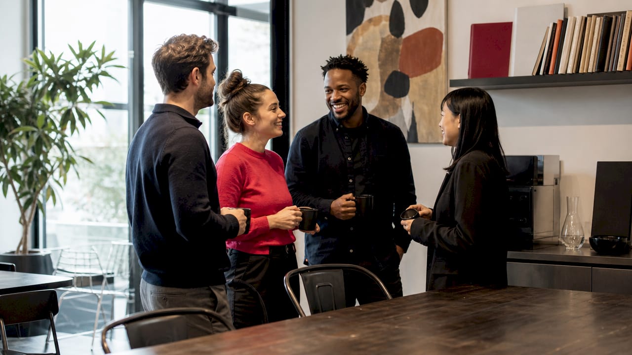 Des professionnels discutent et collaborent dans un espace de travail moderne et partagé.