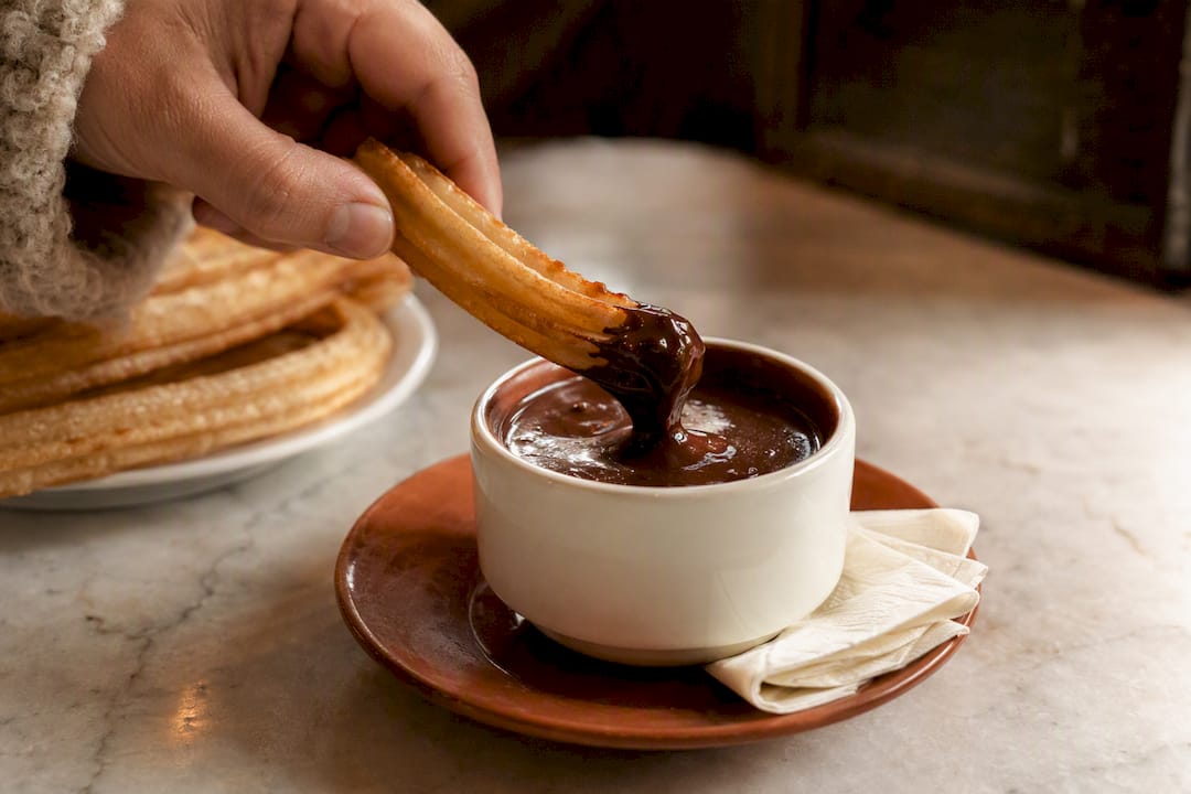 Churro dipped into thick Spanish hot chocolate