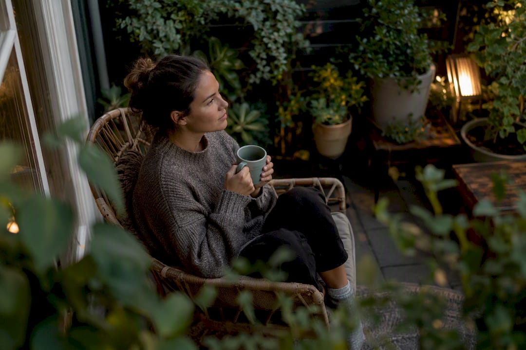 Person holding mug looking thoughtful and tired