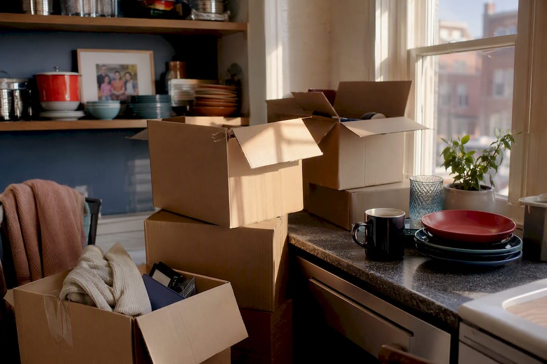 Packed moving boxes and family photo in living room