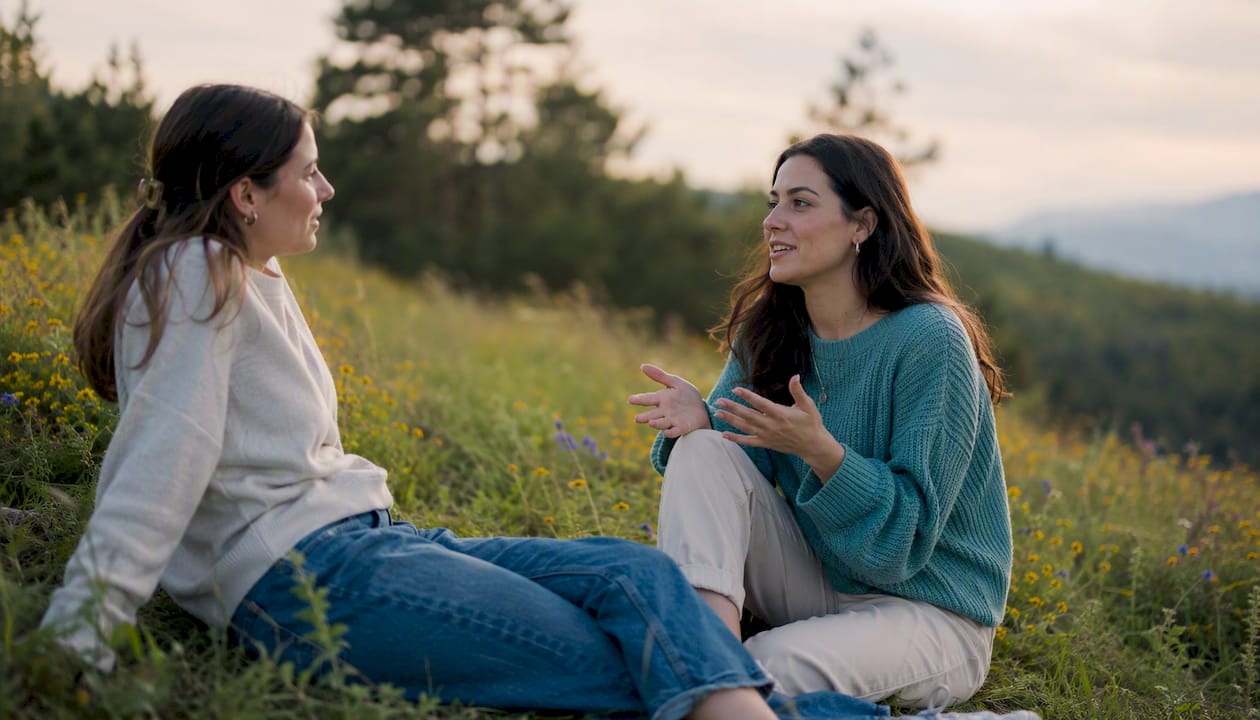 Friends in heartfelt conversation on park bench
