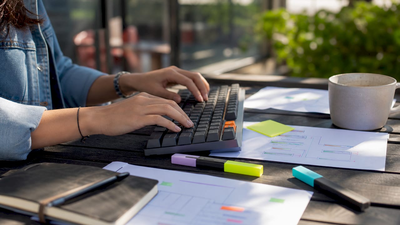 Manos trabajando en la redacción y el análisis de textos con enfoque en su significado
