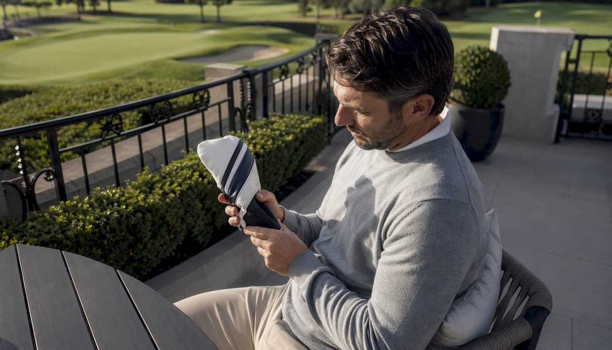 Golfer inspecting golf headcover outdoors