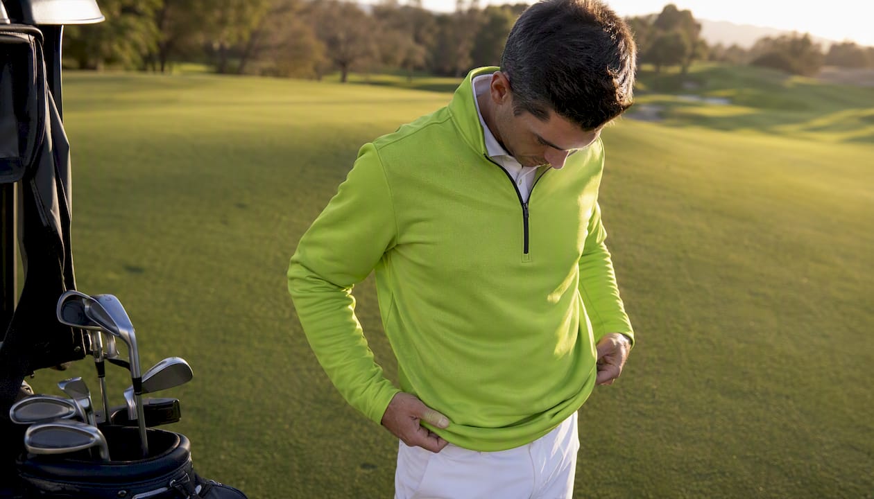 Golfer in lime green quarter-zip jacket