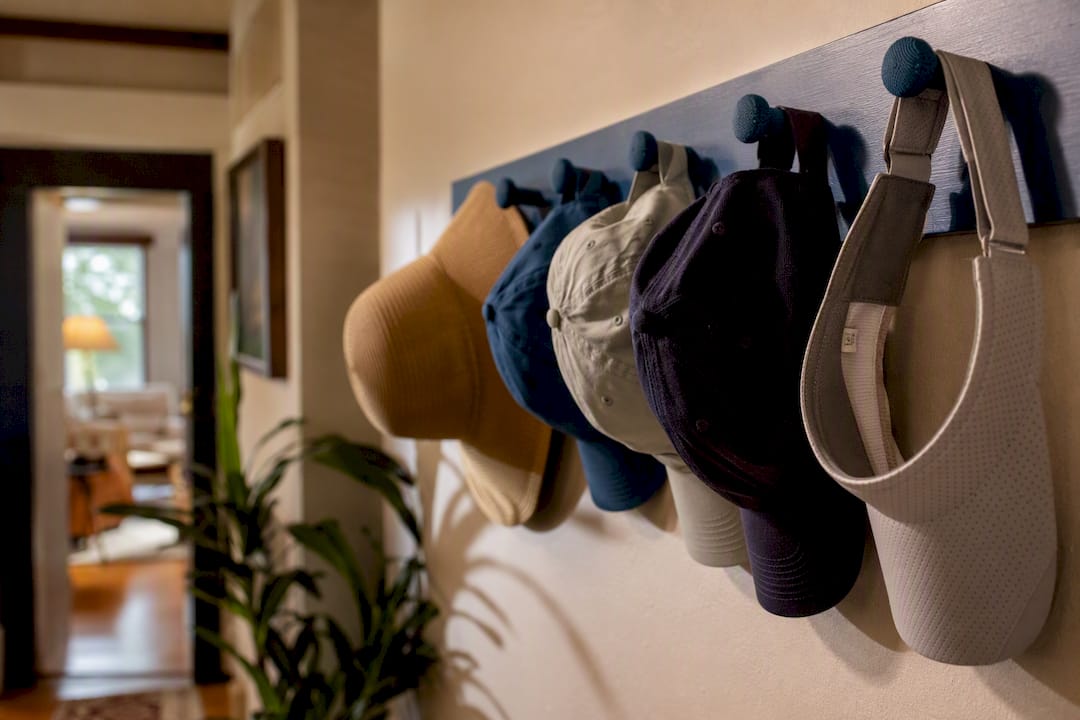 Hats hanging neatly on padded peg rack hooks