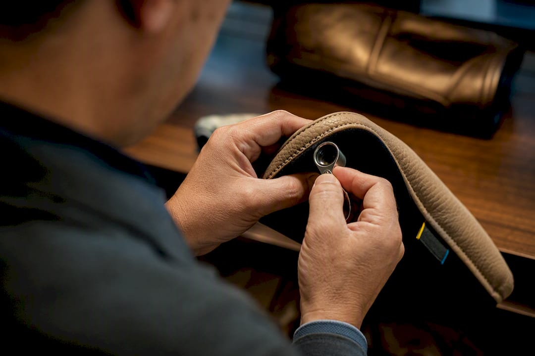 Hands examining headcover stitching