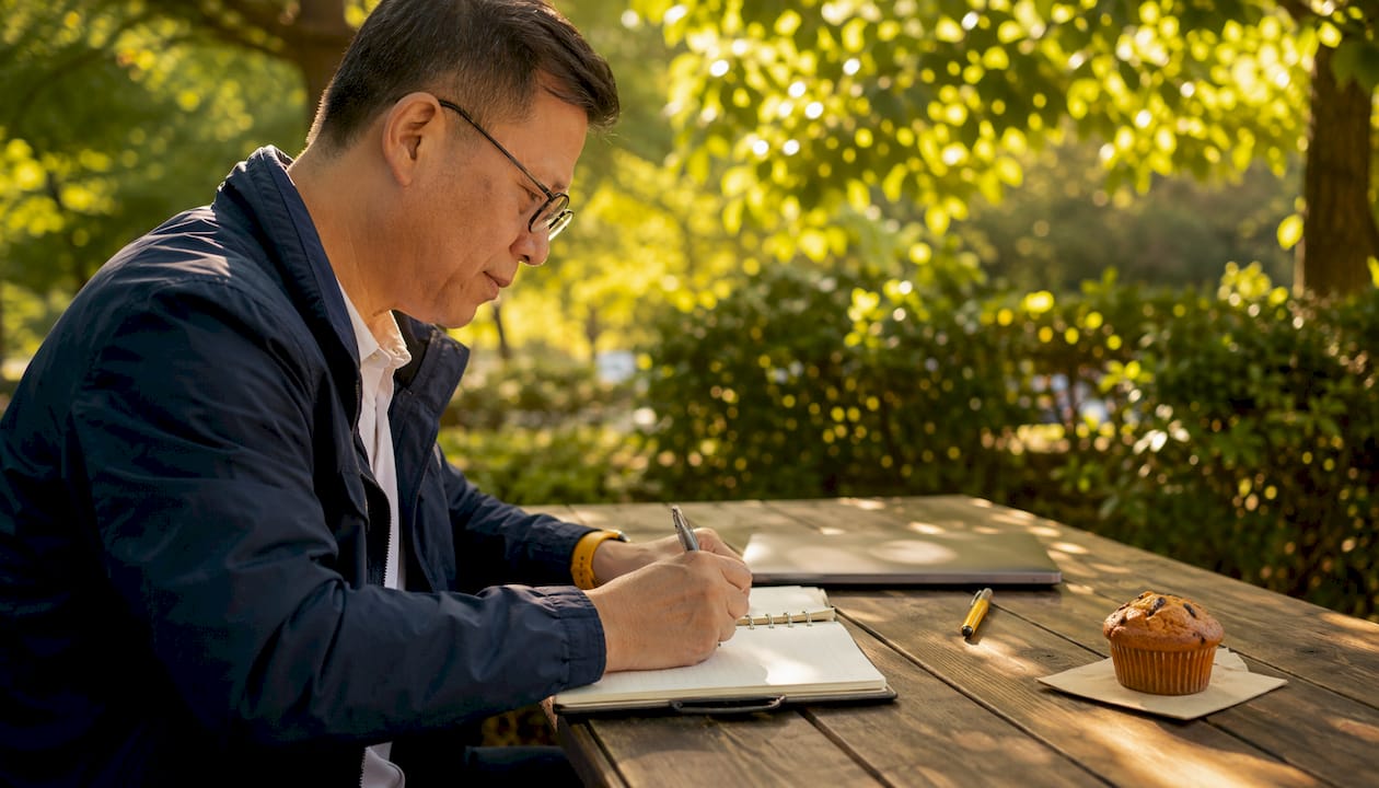 Man planning testimonial request schedule in café