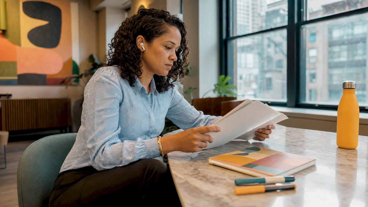 Marketing manager reviewing advocacy playbook in office