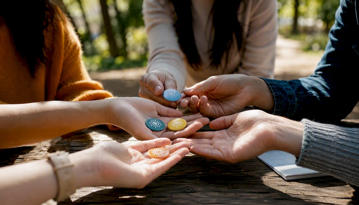 Hands exchanging engagement tokens in community setting