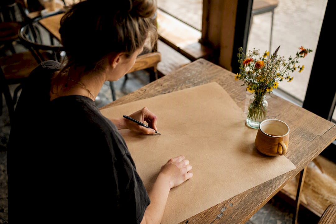 Hands writing social media strategy notes on tablet
