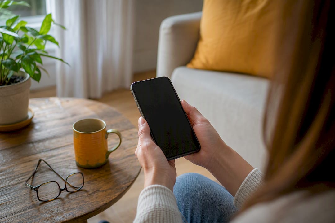 Hands holding smartphone in cozy environment